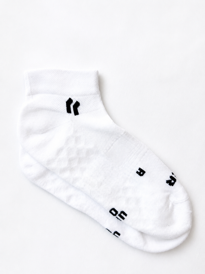 White PAIRR “Stride” ankle socks photographed on a clean white background, featuring a lightweight low-cut silhouette, breathable textured knit zones, and black logo detailing for a minimal performance-inspired look.