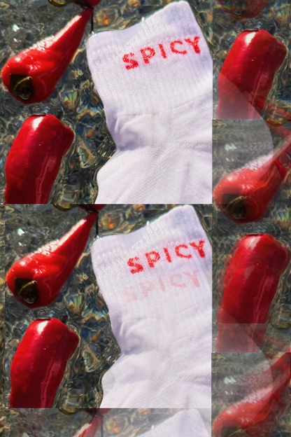 A white ribbed running sock with 'SPICY' printed in red across the top, shown in a collage layout surrounded by glossy red chili peppers on a textured dark background.
