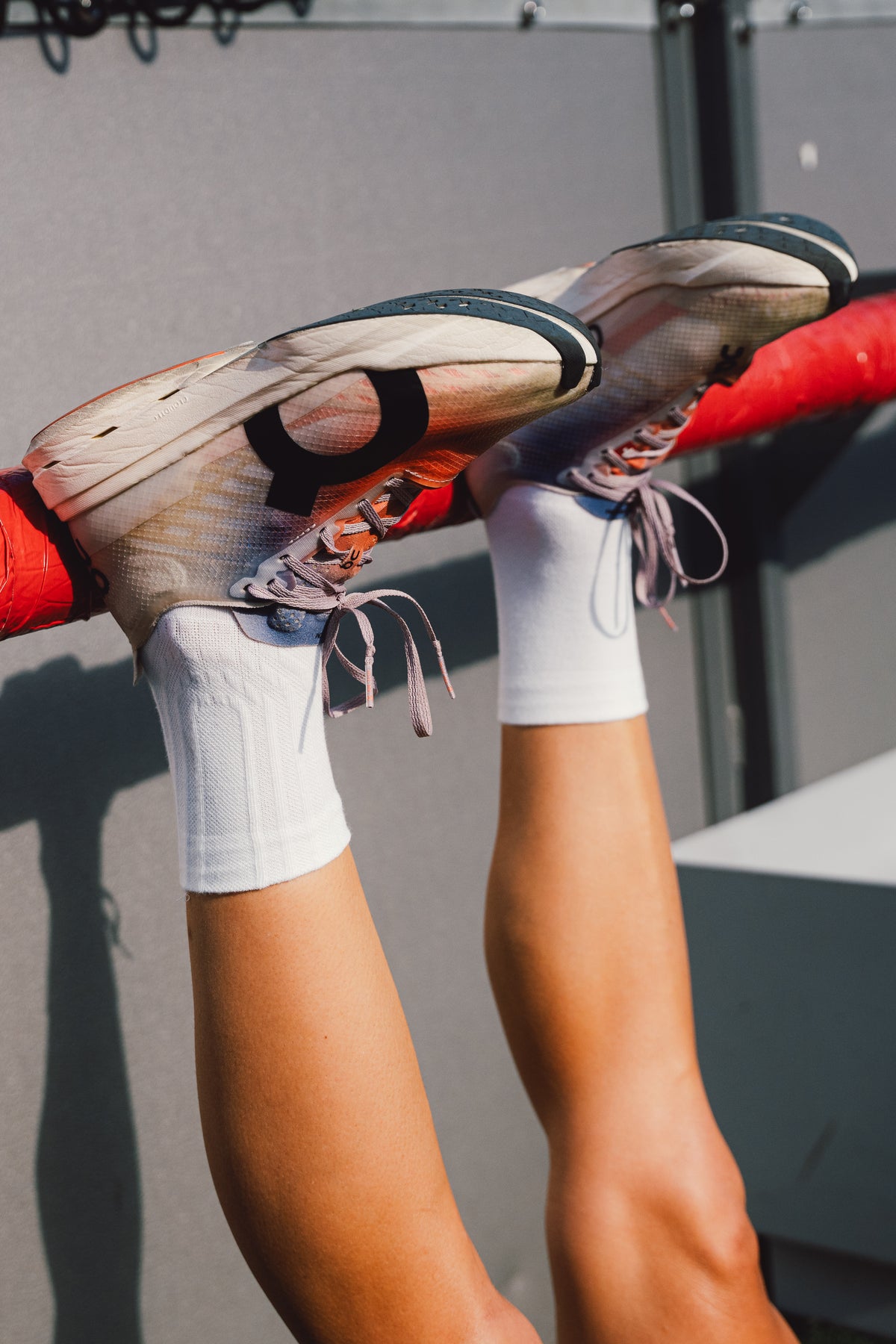 Legs raised showing PAIRR The 400 white crew running socks worn with running shoes. Performance white crew running socks are shown.